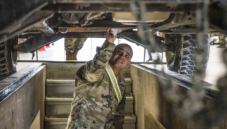 Sgt. Andrew T. Foster inspects a humvee during movement preparation area operations on Fort Sill, Okla., March 10, 2020. Sgt. Foster inspected underneath vehicles during the second station of MPA ops.